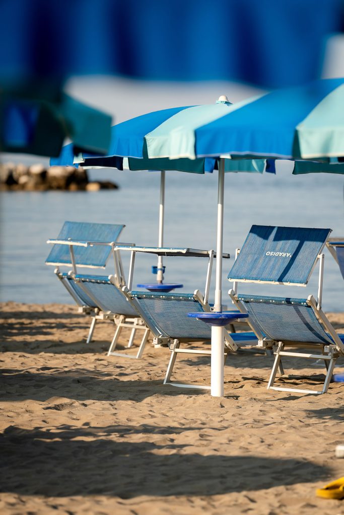 ombrelloni e lettini col mare sullo sfondo
