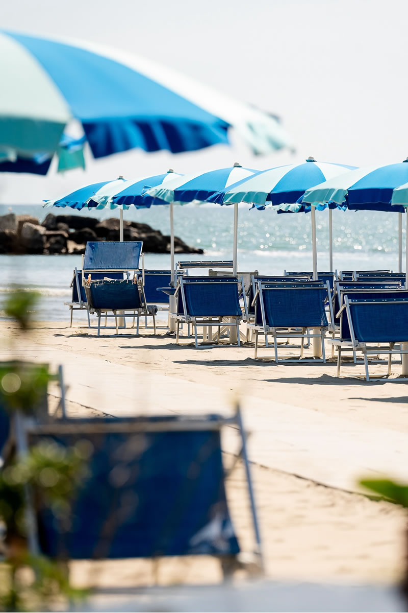 la spiaggia con ombrelloni e lettini e il mare sullo sfondo